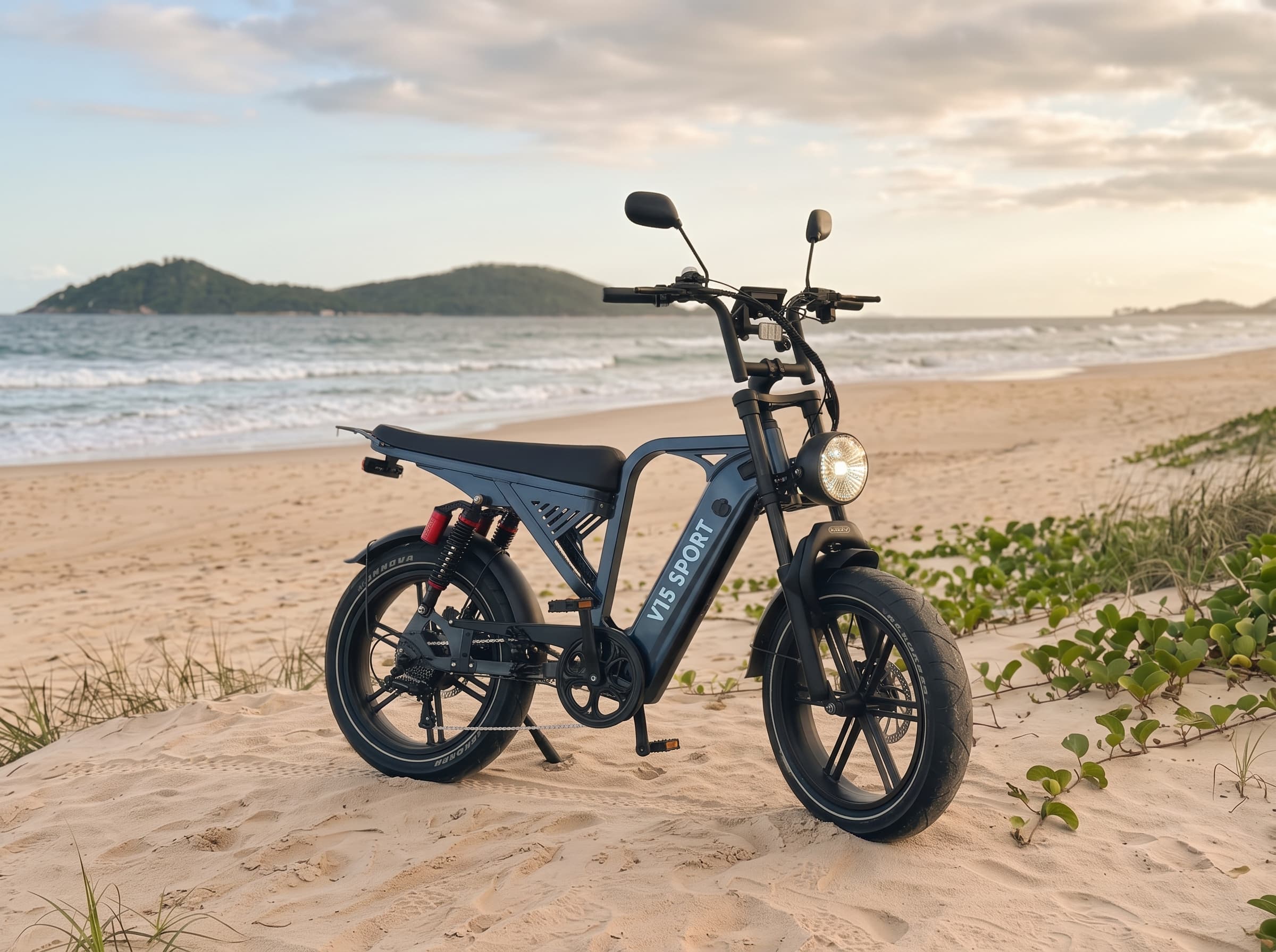 E-bike V15 SPORT azul com pneus largos estacionada na areia da praia