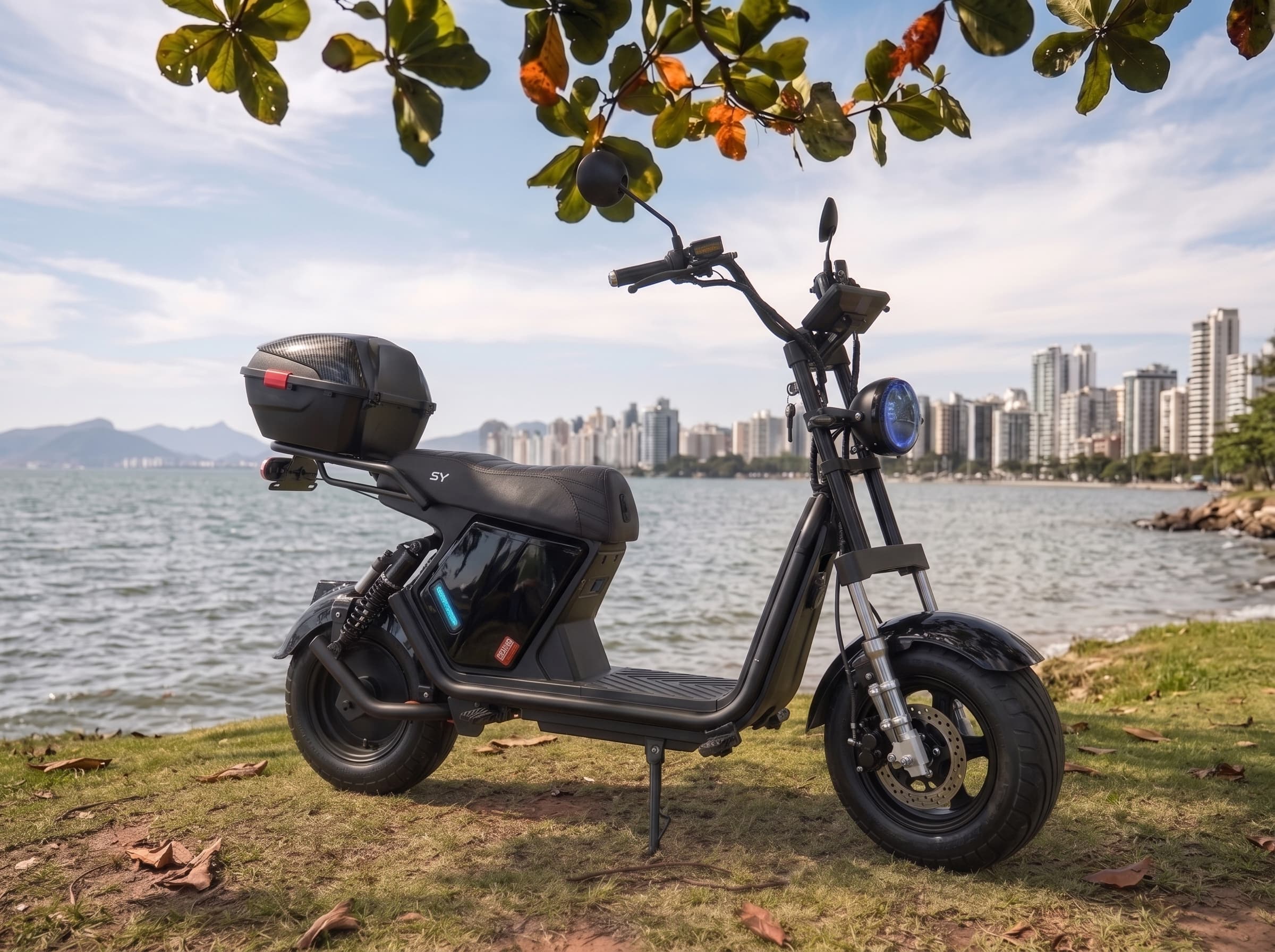 Scooter elétrica X18 Plus preta com baú e farol azul à beira-mar em Florianópolis