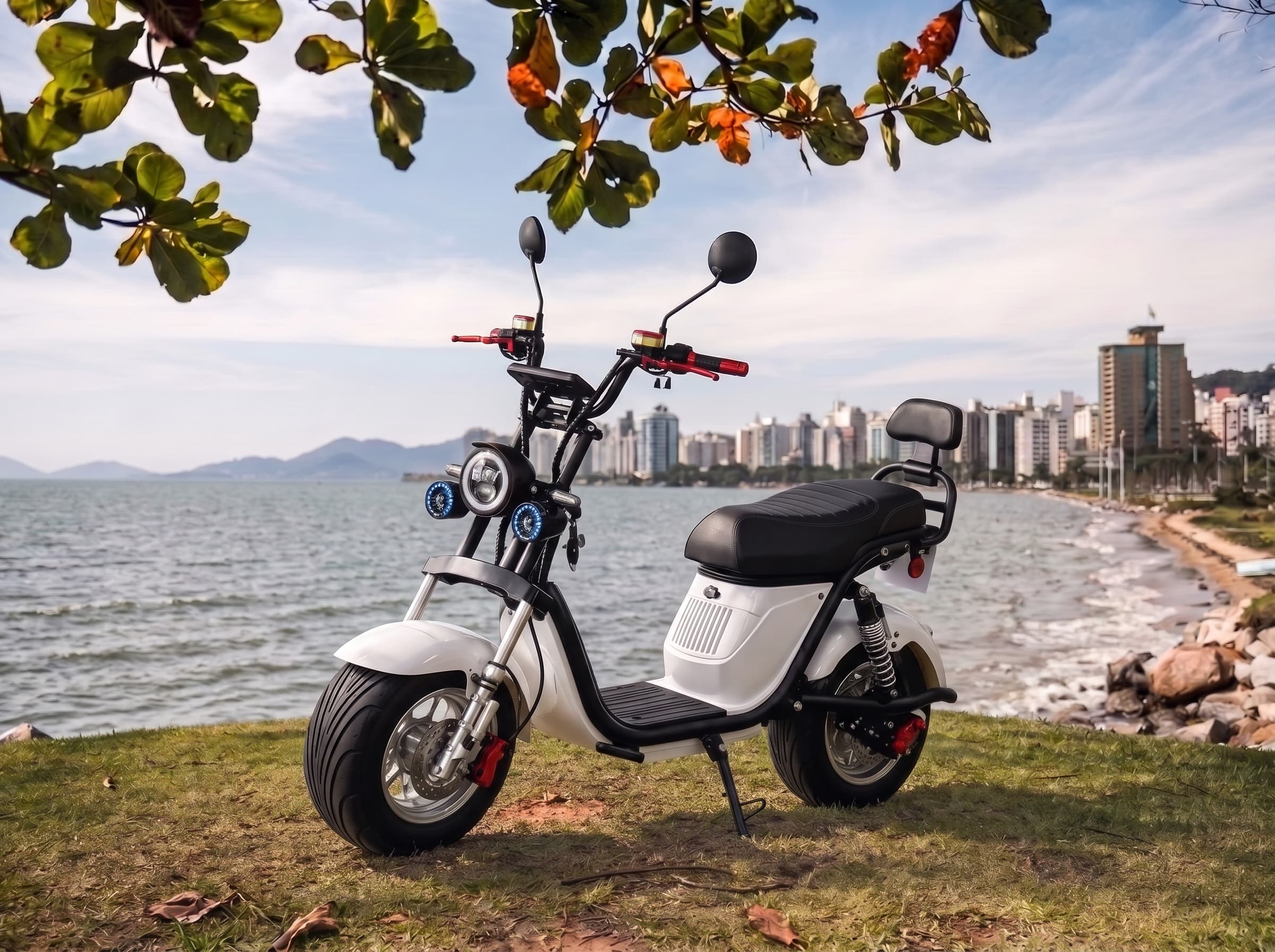 Scooter elétrica S20 Pro branca com pneus largos e encosto traseiro à beira-mar em Florianópolis